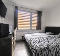 Schlafzimmer mit Bett, Fernseher und Schreibtisch in einer 3-Zimmer-Wohnung.