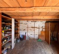 Holzinterieur eines Einfamilienhauses mit Regalen für Werkzeuge und einer Holzdecke.