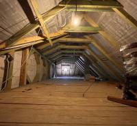 Dachboden in einem Einfamilienhaus mit freiliegenden Balken und Holzboden.