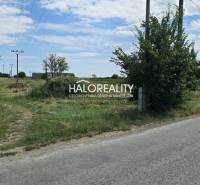 Eine Landstraße bei landwirtschaftlichen und forstwirtschaftlichen Grundstücken in Čierny Brod mit Strommasten.