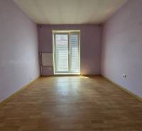 Ein Zimmer mit lila Wänden und Holzboden in einer 2-Zimmer-Wohnung.