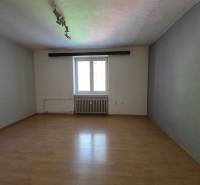 Ein leerer Raum mit Parkettboden und einem Fenster in einer 2-Zimmer-Wohnung.