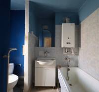 Badezimmer in einer 2-Zimmer-Wohnung mit Badewanne, Waschbecken und Toilette, die Farbtöne der Wände sind blau.