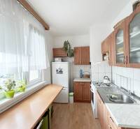 Küche in einer 2-Zimmer-Wohnung mit einem Gasherd und Holzmöbeln.