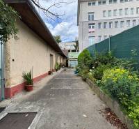Das Äußere eines Einfamilienhauses in Ilava mit einer Gasse und Blick auf ein höheres Gebäude.