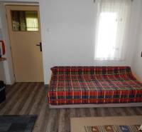 Chata mit einem bequemen Sofa, einem Teppich und einer Tür, die in einen weiteren Raum führt.
