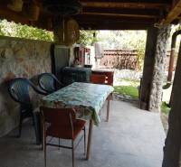 Steinterrasse bei der Hütte in Klížska Nemá mit Tisch und Stühlen unter einem Unterstand.
