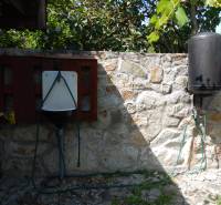 Steinmauer in Klížska Nemá mit Waschbecken und Tank bei der Hütte.