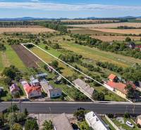 Grundstücke zum Wohnen in Sečovce, grüne Felder, einige Häuser und eine große Straße vorne.