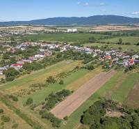 Panoramablick auf Sečovce mit weitläufigen Wohngebieten und umliegenden Feldern.