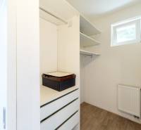 Ein Kleiderschrank mit Schubladen und Regalen in einer 4-Zimmer-Wohnung mit Fenster und Heizkörper.