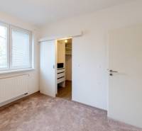 Ein Zimmer mit Teppichboden und einem Einbauschrank in einer 4-Zimmer-Wohnung.