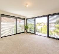 Geräumiger Wohnbereich mit großen Fenstern, Jalousien und Aussicht aus einer 4-Zimmer-Wohnung.