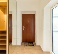 Eingangsbereich mit Garderobe in einer 4-Zimmer-Wohnung, Holztüren, helles Interieur.