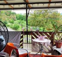 Die Terrasse des Einfamilienhauses mit Schaukel und Pflanzen bietet einen Blick ins Grüne.