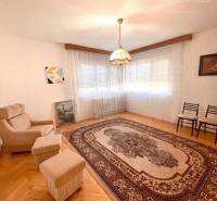 Wohnzimmer in einem Einfamilienhaus, Sessel, Teppich mit Ornamenten und Hängelampe.