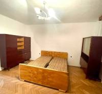 Schlafzimmer in einem Einfamilienhaus mit älteren Möbeln und Holzboden.