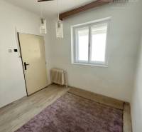 Zimmer in einem Einfamilienhaus, helles Interieur, Holzbalken, Kronleuchter, violetter Teppich.