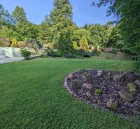 Der Garten des Einfamilienhauses in Nová Baňa mit Rasen und Ziersträuchern.