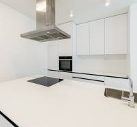 Küche in einer 3-Zimmer-Wohnung mit weißen Schränken, Kochfeld und Spüle.