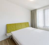 Helles Schlafzimmer mit großem Fenster und Bett in einer 3-Zimmer-Wohnung.