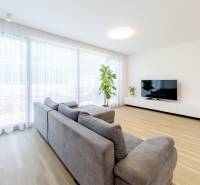 Wohnzimmer in einer 3-Zimmer-Wohnung mit geräumigem Sofa und Holzboden.