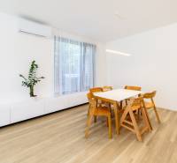 Esstisch und Stühle auf einem Boden mit Holzdekor in einer 3-Zimmer-Wohnung.