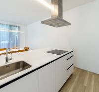 Küche in einer 3-Zimmer-Wohnung mit Spüle, Dunstabzugshaube und Boden mit Holzdekor.