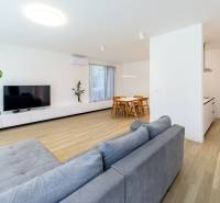 Geräumiges Wohnzimmer in einer 3-Zimmer-Wohnung mit Holzboden und großem Fernseher.