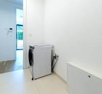 Weiße Waschküche mit Geschirrspüler in einer 3-Zimmer-Wohnung, Boden mit Holzdekor.