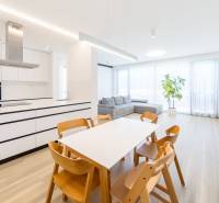 Helles Wohnzimmer mit Esstisch, Küche und Holzboden.