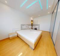 Schlafzimmer in einer 4-Zimmer-Wohnung mit Holzboden und Bett.