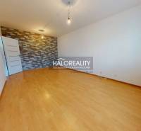 Ein Zimmer in einer 4-Zimmer-Wohnung mit Parkettboden und dekorativer Ziegelwand.