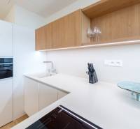 Küche in einer 2-Zimmer-Wohnung mit weißen und hölzernen Schränken, Whirlpool-Geräte.