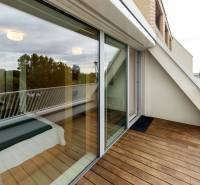 Dachterrasse mit Holzboden und Verglasung in einer 2-Zimmer-Wohnung.