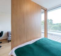 Innenraum einer 2-Zimmer-Wohnung mit Küche, Bett und Terrasse mit Ausblick.