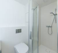Badezimmer mit Dusche und Toilette in einer 2-Zimmer-Wohnung.