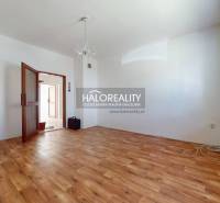 Geräumiges Zimmer mit Holzboden, Kronleuchter und offenen Türen in einem Einfamilienhaus.