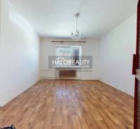 Ein leerer Raum mit Holzboden und einem Kronleuchter in einem Einfamilienhaus.
