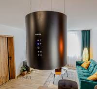 Wohnzimmer mit Kronleuchter, grünem Sofa und dekorativen Kissen in einer 3-Zimmer-Wohnung.