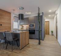 Stilvolle Küche in einer 3-Zimmer-Wohnung mit Holz- und grauen Akzenten.