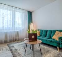 Wohnzimmer in einer 3-Zimmer-Wohnung mit Sofa, Tisch und Blumen, helle Atmosphäre.