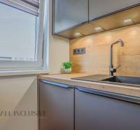 Küche in einer 3-Zimmer-Wohnung mit schwarzem Spülbecken und Holzarbeitsplatte.