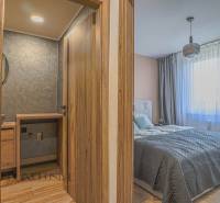 Schlafzimmer und Badezimmer in einer 3-Zimmer-Wohnung mit hölzernen Eingangstüren.