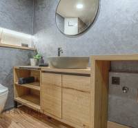 Badezimmer in einer 3-Zimmer-Wohnung mit Holzmöbeln und moderner Sanitärtechnik.