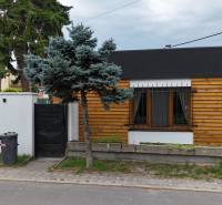 Ein Einfamilienhaus in der Poľná-Straße in Most pri Bratislave mit Holzverkleidung und Garten.