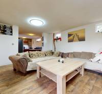 Wohnzimmer in einem Einfamilienhaus mit einem bequemen Sofa, einem Holztisch und Dekorationen.
