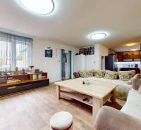Wohnzimmer in einem Einfamilienhaus mit Holztisch, Sofa und Bücherregal.