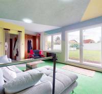 Wohnzimmer in einem Einfamilienhaus mit Sofa, Couchtisch und Blick in den Garten.