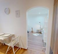 Essbereich mit zwei Stühlen führt in das Wohnzimmer in einer Einzimmerwohnung.